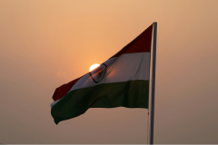 The flag of India billowing under a sunset