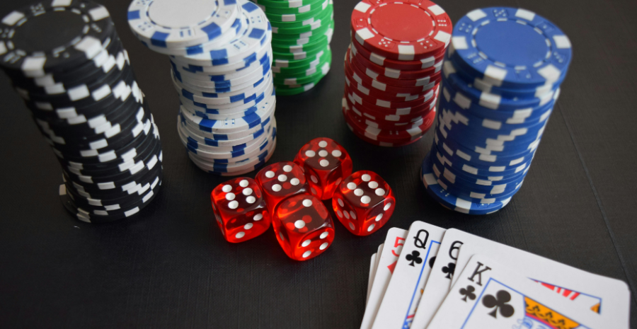 A stack of poker chips near a hand of cards