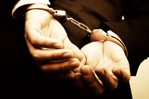 Thailand raids illegal gambling bar for Myanmar nationals, finding drugs and ammunition. Stock image of person in handcuffs