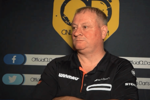 Andy Jenkins banned 11 years for match fixing in darts scandal. Screenshot of darts player Andy Jenkins wearing dark sleeveless shirt in front of Online Darts yellow logo.