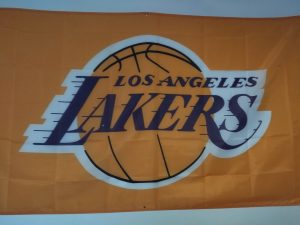 Los Angeles Lakers sign on a banner, orange background, basketball in the center. Sports logo is royal purple.