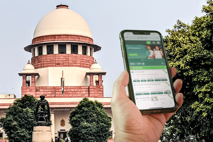 India's Supreme Court to review plea seeking ban on betting and fantasy sports apps. India's Supreme Court building behind person holding smartphone using sports betting app.