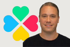 Lotto.com CEO says Texas Lottery scandal sparked unexpected boost for courier growth. Lotto.com CEO Thomas Metzger against blue, green, red, and yellow clover Lotto.com logo.