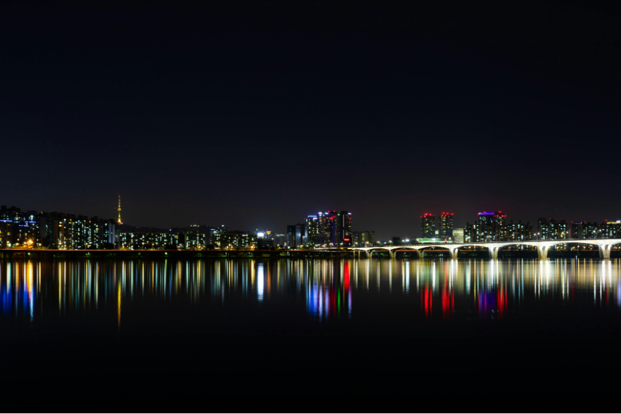 A South Korean skyline lit at night across the water