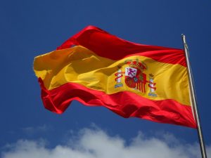 The Spanish flag billowing on a sky blue background