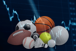 Tribal leaders say prediction markets pose 'existential threat' to Indian gaming. Range of different sports equipment including basketball, soccer, and football in front of graph.