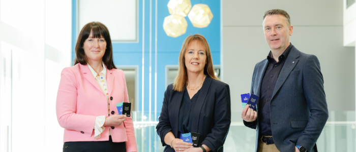 Three people holding bank cards.