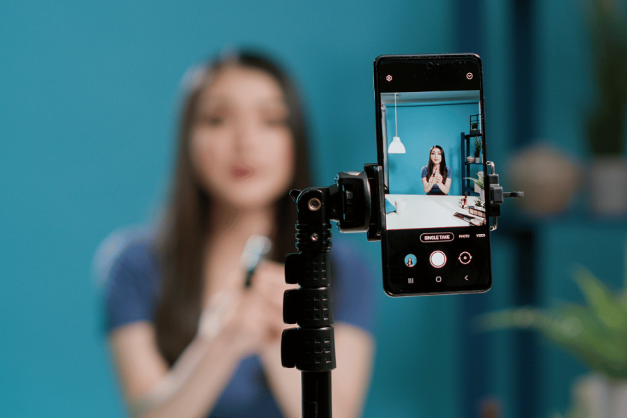 ACMA warns influencers that promoting illegal gambling can lead to penalties. Blurred image of influencer in front of camera