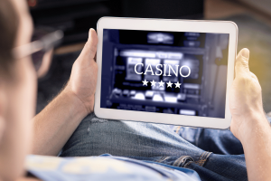 California targets sweepstakes casinos in major move against illegal online gaming. Man playing on an online casino on his tablet