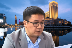 Macau lawmaker demands cuts to foreign casino labor amid closures. Macau lawmaker Ron Lam in front of cityscape of Macau with casino