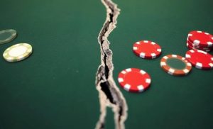 A casino table is ripped in two amongst poker chips