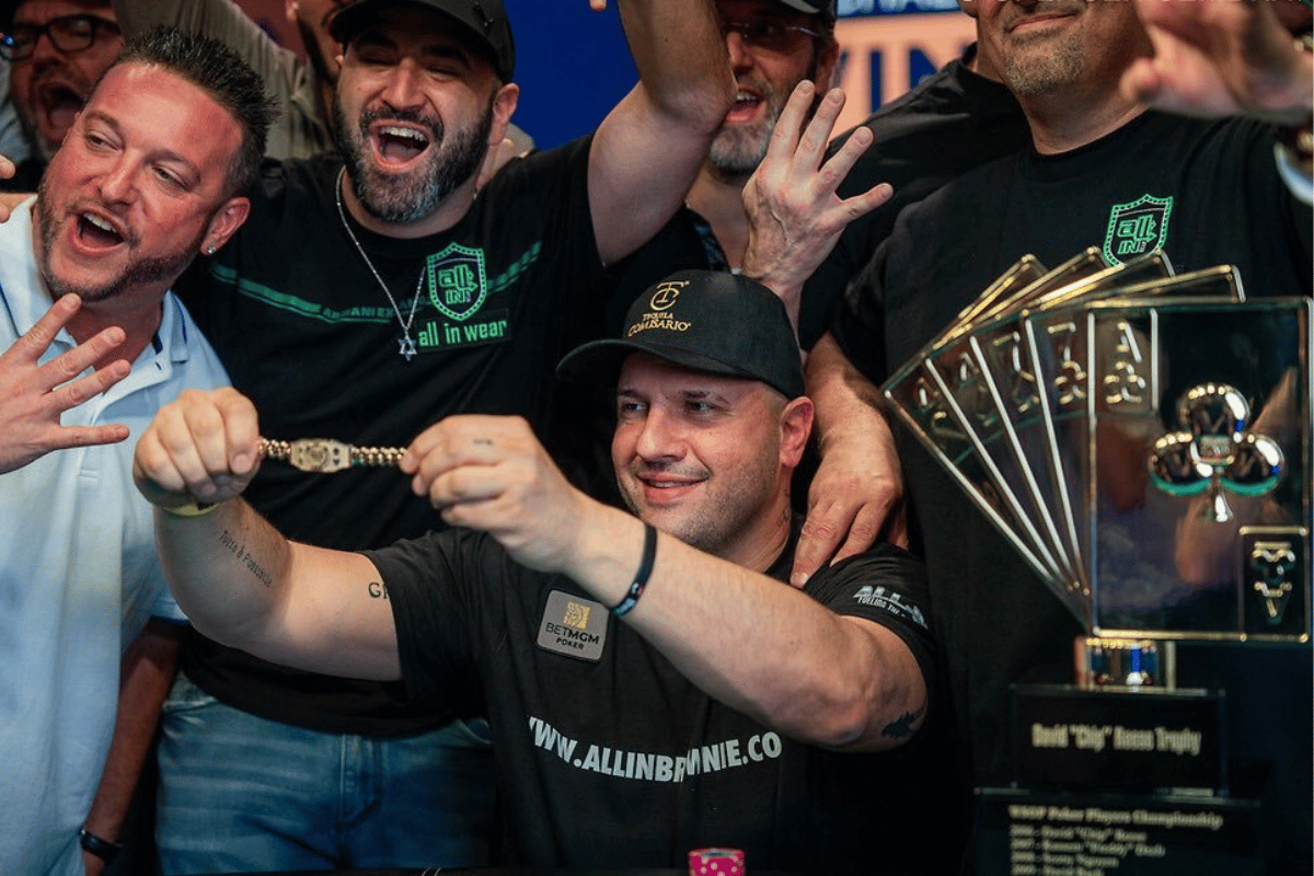 Turnouts and wins WSOP 2025 sees history made. Michael Mizrachi celebrates his WSOP 2025 victory surrounded by cheering supporters. He holds up a gold bracelet with a big smile as others gesture excitedly. A large trophy featuring playing card suits and the text “David ‘Chip’ Reese Trophy” is visible on the table.