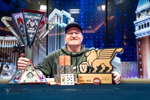 MSPT Hall of Famer Josh Reichard wins the inaugural MSPT Heart Poker Championship / Reichard poses with his trophy, his chips, and his pay cheque.