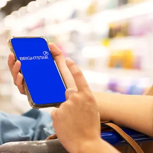 Close up of two hands holding a phone with a blue screen saying 'Brightstar.'