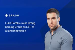 Bragg logo on a blue background, man stood on the right hand side. Bragg Gaming Group embraces AI as it announces new EVP hire