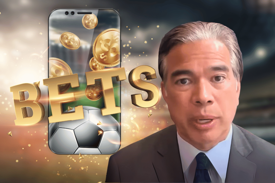 California AG Rob Bonta plans action against fantasy sports platforms. California Attorney General Rob Bonta speaks, with a background image of a smartphone showing gold coins, a soccer ball, and the word "BETS" in bold gold letters, symbolizing online sports betting and fantasy sports platforms.