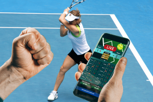 Dutch Gambling Authority orders ZEbetting and Betca to halt illegal tennis bets. A person holding a smartphone showing live tennis betting options, with a clenched fist in the foreground and a female tennis player hitting a backhand on a blue court in the background.