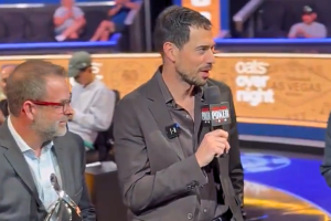 Nick Schulman enters the 2025 Poker Hall of Fame. Schulman is seen holding a microphone with the words 'WSOP' on it, as a man in a suit holds Hall of Fame award