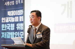 Man stood on stage wearing a suit and speaking into a microphone, with a banner behind him which is written in Korean. Kangwon Land co-hosts an addiction prevention forum in South Korea