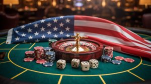 A photograph of an American flag draped over a dark green felt poker table. Scattered across the table are stacks of red, white, and blue poker chips alongside several ivory dice displaying the numbers five and three. A single gold-rimmed roulette wheel stands slightly off-center, illuminated by a focused spotlight casting long shadows across the table. The background is a softly blurred, dimly lit casino lounge, emphasizing the focused scene.