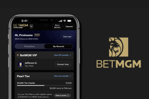 Betmgm announces the redesign of a new application before a new football season. The Mobile Betmgm interface is displayed on a smartphone screen that shows VIP bonuses and loyalty specifications, with the Betmgm logo that features a lion's head on the right side.