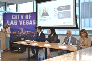 Nevada experts warn federal tax change could harm gambling industry. Congresswoman Dina Titus speaks at a podium during a town hall on the FAIR BET Act at Las Vegas City Hall, with a panel of four experts seated beside her, including Adam Robinson, Becky Harris, Russell Fox, and Virginia Valentine. A large "City of Las Vegas" backdrop and a projected presentation slide are visible behind them.