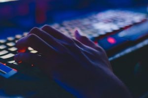 Hand on the lighting keyboard in a dark room. The e -crime agency in Pakistan lists gambling and illegal trading applications