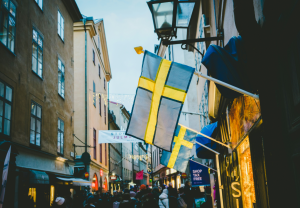 Spelinspektionen has proposed a new set of regulations for Spelpaus, its nationwide self-exclusion tool. Swedish blue and yellow flags hang from side of a building.