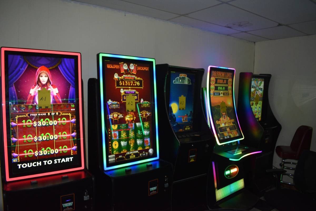 Dark room, with five gambling machines lined up next to each other