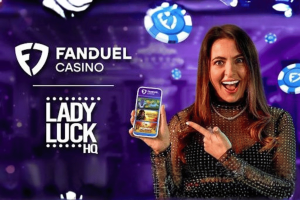 FanDuel casino adds influencer as newest ambassador. A smiling woman with long brown hair points excitedly at a smartphone she is holding, which displays the FanDuel Casino app. She stands against a purple casino-themed background with floating poker chips. To the left of her are the FanDuel Casino logo and the text “Lady Luck HQ.”