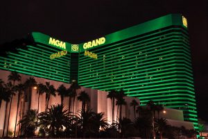 Exterior of MGM Grand hotel in Las Vegas, a green light has been shone on the building. Palm trees are lined in front. MGM Resorts third-quarter financial report is in, with China seeing a rise