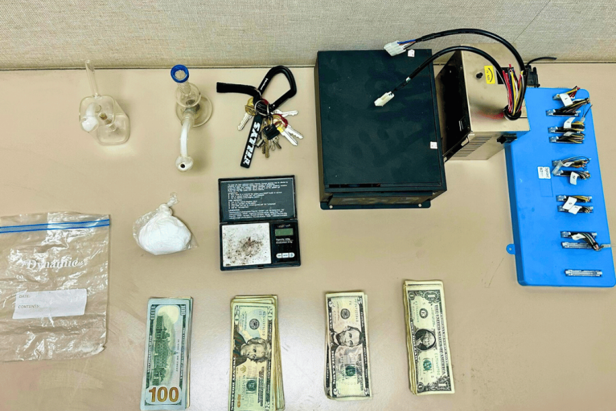 Evidence displayed on a table, including cash, suspected narcotics, drug paraphernalia, electronic equipment, and keys seized during a Lake Isabella search. Two arrested in Lake Isabella raid as California targets illegal gambling