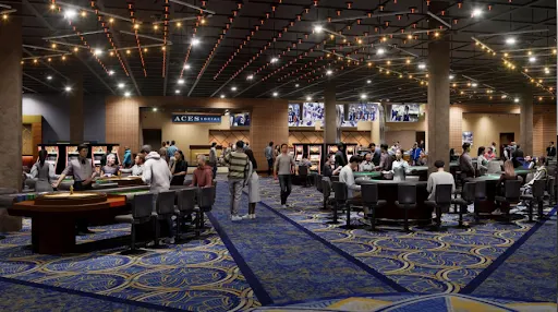 Vista ampla de um movimentado cassino com pessoas reunidas em torno de mesas de jogos e caça-níqueis, com carpete azul estampado, luzes suspensas e diversas áreas de jogos.