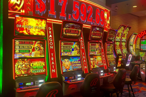 Inside of a casino, four gambling machines lined up beside one another - each glowing red. Bally's Colorado casino workers able to join Teamsters union