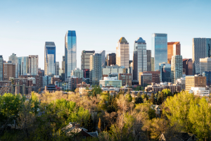 Skyline of Calgary, with foliage in the forefront and skyscraper-like buildings in the background. Five arrested in Calgary for alleged casino fraud following staff investigation