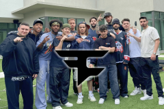 FaZe Clan faces uncertain future as creators exit after failed talks. A group of young men posing together outdoors in front of a modern building, wearing casual streetwear, with a large FaZe Clan logo overlaid in the center of the image.