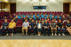 The Singapore Police ambassadors sat on chairs in a small auditorium-like room. Singapore Police announces new ambassadors for migrant workers, working to tackle gambling dangers