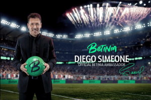Diego Simeone announced as new Betinia ambassador. Diego Simeone holding green Betinia football in stadium, announced as official Betinia ambassador with fireworks in background.