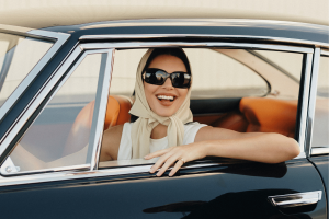 Fanatics sportsbook bets on Kendall Jenner in debut Big Game commercial. Kendall Jenner wearing sunglasses and a headscarf smiles from the driver’s seat of a vintage black car in a stylized commercial setting.
