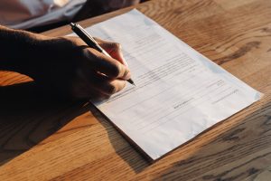 A person sitting at a table filling in a document. Why the new IRS draft gambling reporting threshold matters