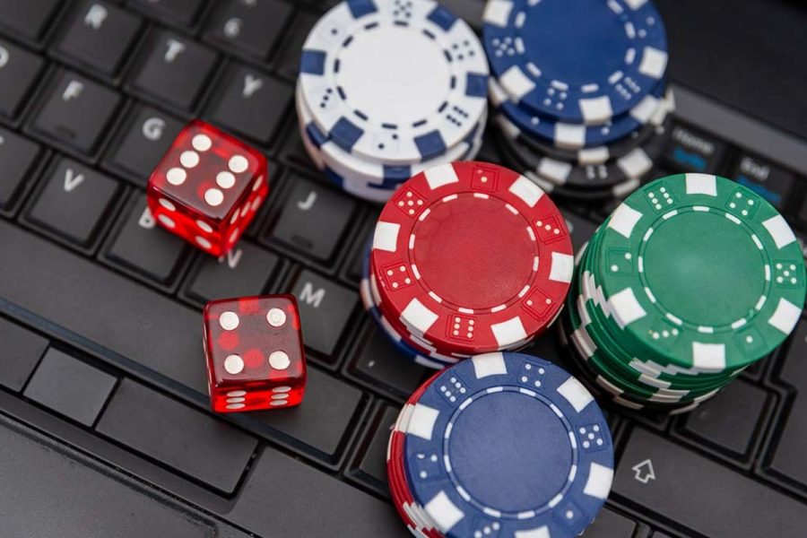 A handful of gambling chips and dice on a keyboard. Finland unveils new operator license fees ahead of 2027 Gambling Act
