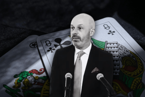 Thomas Goldstein convicted in sweeping federal tax case: high-stakes poker and the fall of a Supreme Court lawyer. Thomas Goldstein in a suit and tie speaks at two microphones, set against a graphic backdrop of oversized playing cards, including queens of clubs and diamonds, suggesting a gambling or poker-related theme.