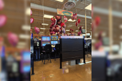 Viral post sparks debate over Kroger gambling machines in Georgia. A section inside a grocery store labeled “Georgia Skill Games” featuring slot style machines behind dark partitions, with chairs in front and heart shaped balloons displayed above the area.