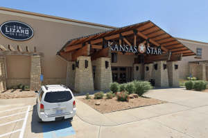 Wichita man accused of running proxy betting scheme at Kansas casino. Front entrance of Kansas Star Casino in Mulvane, Kansas, featuring a wooden canopy with stone columns, a “Kansas Star” sign above the doors, a Tin Lizard Bar & Grill sign on the exterior wall, and a white SUV parked in a handicap space near landscaped shrubs.