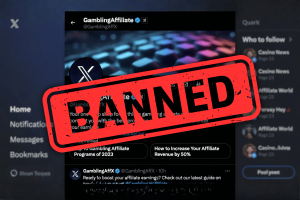 X updates paid partnerships policy banning gambling related promotions on platform. Screenshot of an X (formerly Twitter) profile called “GamblingAffiliate” with a large red “BANNED” stamp over the account page, indicating the account has been suspended or blocked.