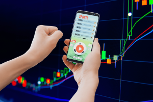 Americans see sports prediction markets as gambling survey finds growing concern. Sports betting app on smartphone with rising stock market chart background, illustrating prediction markets, online gambling, and financial trading risk concepts