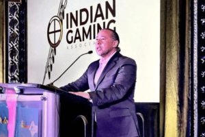 Indian Gaming Association chairman speaking at podium during conference on tribal gaming policy and sports betting regulation. IGA backs bipartisan Senate bill targeting sports prediction markets