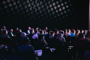 People sitting in chairs at a conference.