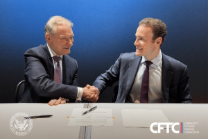 Two men in business suits shake hands across a table while signing documents, with CFTC and SEC logos visible in the background, symbolizing regulatory cooperation between the agencies. US regulators CFTC and SEC move closer together as crypto and prediction markets expand