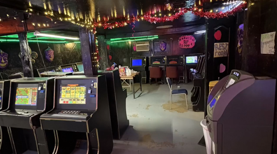 Interior de uma operação de jogo ilegal no condado de Bexar com máquinas de jogos, pouca iluminação e assentos descobertos durante a operação em San Antonio